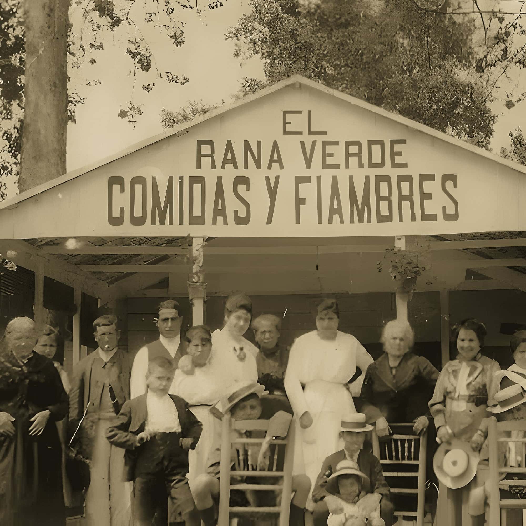 Foto antigua de El Rana Verde: el rótulo «Comidas y fiambres» y un grupo de personas posando delante.