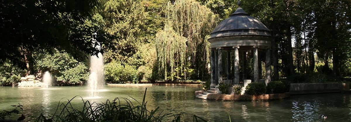 Un templete junto a un estanque con surtidor en un jardín de Aranjuez.