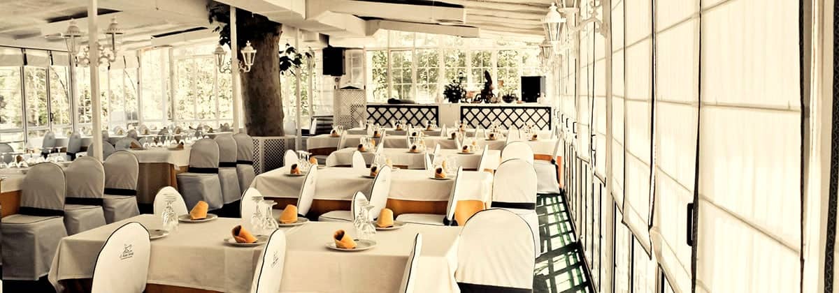 Un salón acristalado del restaurante, con las mesas montadas.